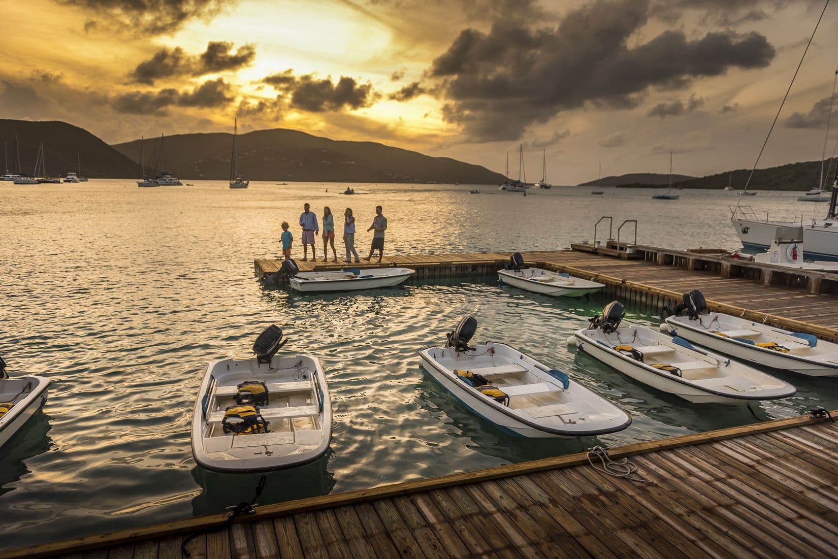 bvi dinghy people standing on dock sunset
