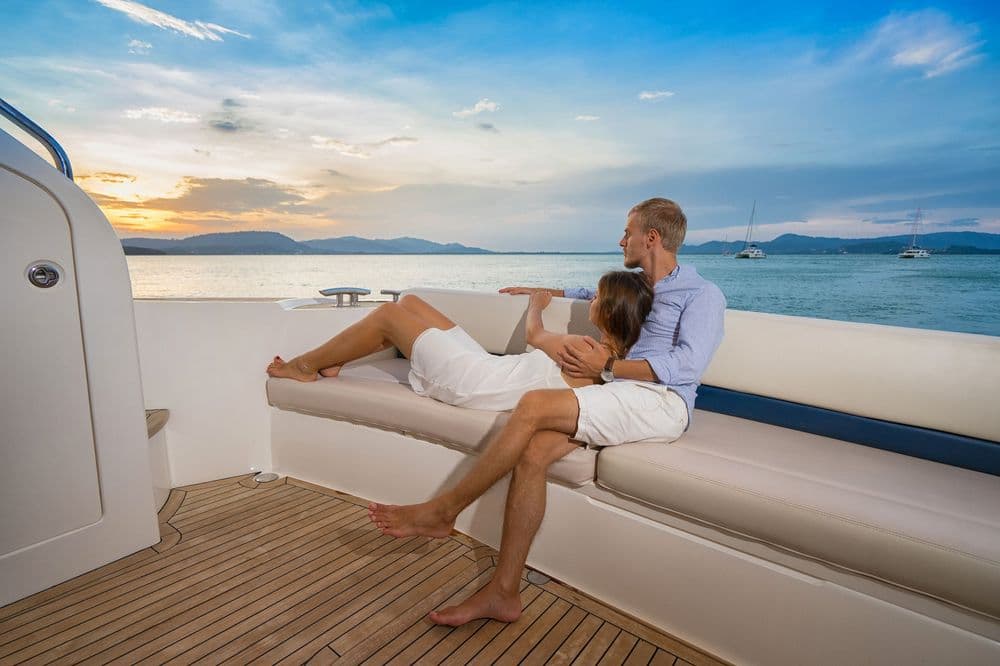 romantic sailing holiday couple watching the sunset on deck
