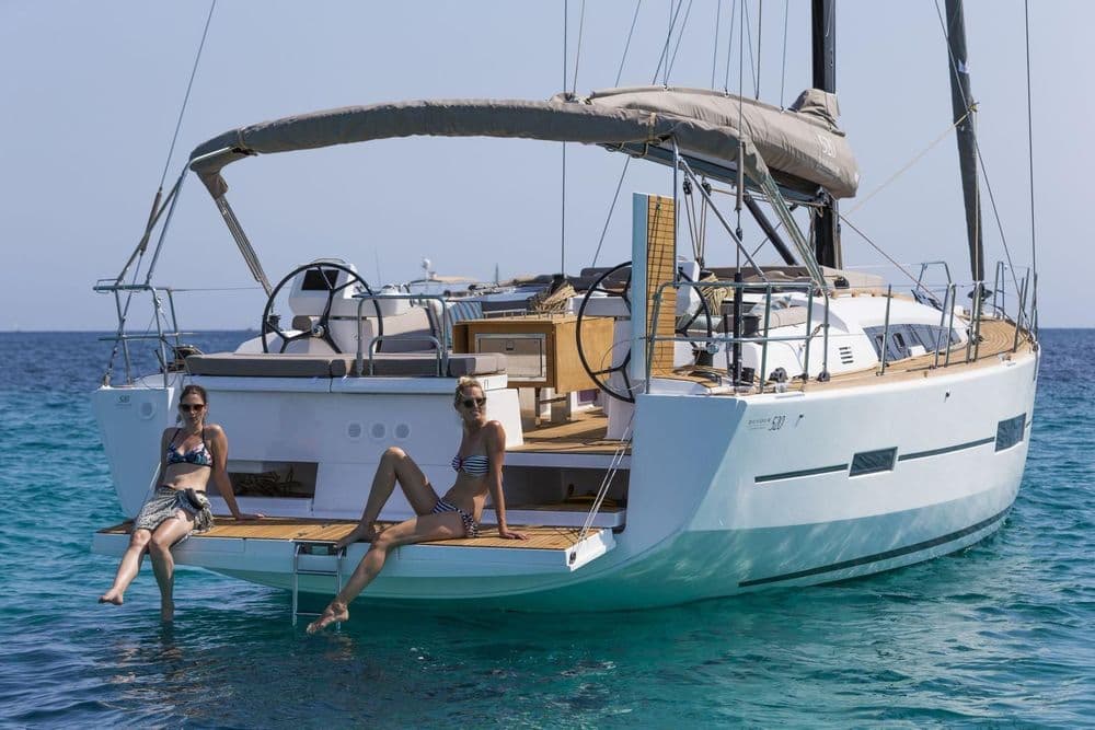 dufour 520 blue bayou three people back of boat cooking